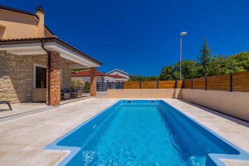a swimming pool in the backyard of a house at Holiday house DIVNA in Pinezici
