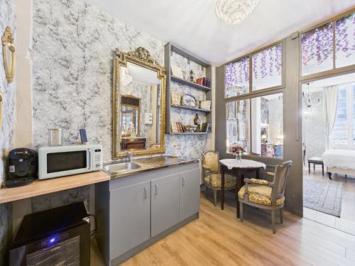 une cuisine avec un évier et un micro-ondes dans l'établissement La Chronique des Bridgerton, à Troyes