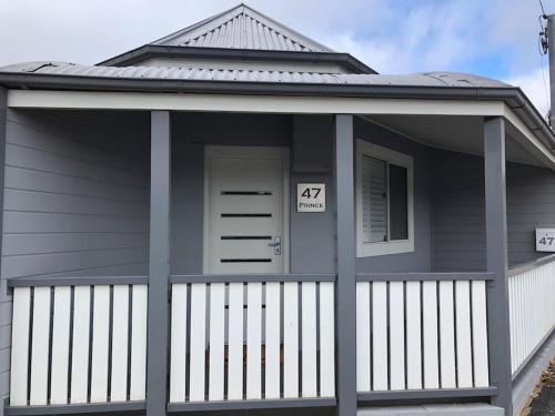 a house with a front porch with the number seventy seven at A Prince on Clinton in Orange