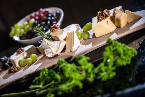 a bunch of different types of cheese and grapes at Sonnenhof Genusshotel & Appartements in Pertisau