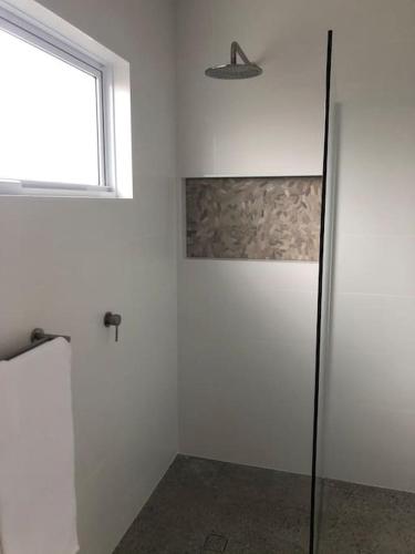 a bathroom with a shower and a window at Cozy on Clinton in Orange