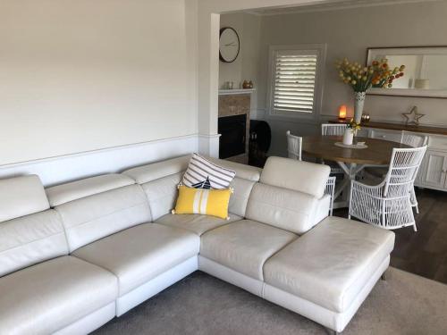 a living room with a white couch and a table at Armara Views in Orange