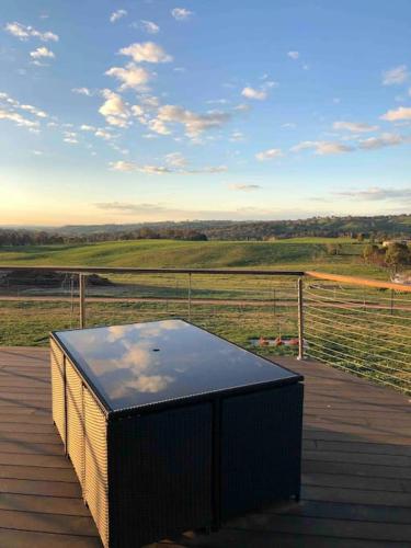 a table on a deck with a view of a field at Armara Views in Orange