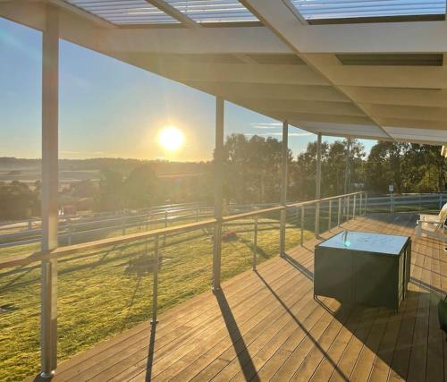 a view of the sunset from a balcony with a table at Armara Views in Orange