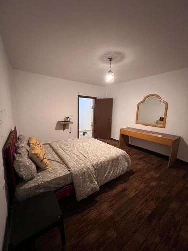 a bedroom with a bed and a large mirror at Happy Bedouin House Petra in Al Ḩayy