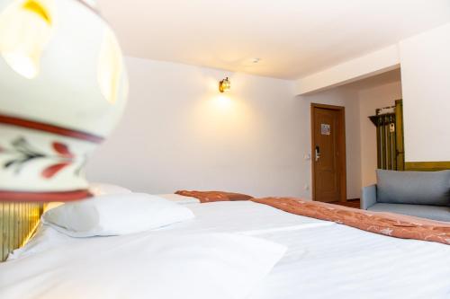 a bedroom with a white bed with a hat on it at Sport - Camere de inchiriat Cheile Gradistei in Moieciu de Jos