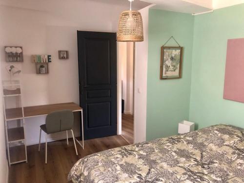 - une chambre avec un lit, un bureau et une porte dans l'établissement Mon nid aux rochers, à La Garde