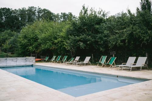 a group of lounge chairs and a swimming pool at Country Lodge in Les Épasses