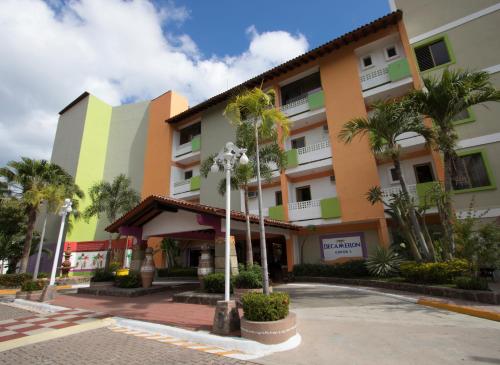 a building with palm trees in front of it at Decameron Los Cocos Guayabitos, Ramada All-Inclusive Resort in Rincon de Guayabitos