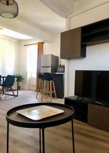 Il comprend un salon doté d'une table et d'une télévision à écran plat. dans l'établissement Mon nid aux rochers, à La Garde