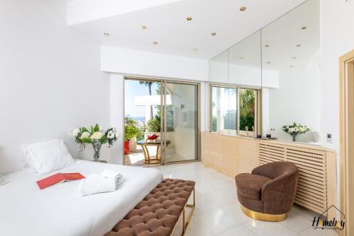 une chambre avec un grand lit et une chaise dans l'établissement Villa Prestige Hammam & Piscine, à Cannes