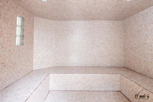 une pièce carrelée blanche avec une baignoire dans l'établissement Villa Prestige Hammam & Piscine, à Cannes