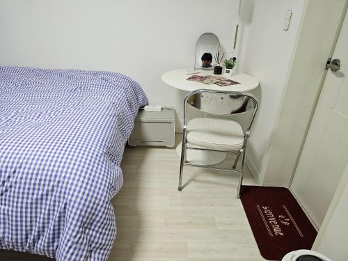 a bedroom with a bed and a table and a chair at Premium Incheon Apart in Incheon