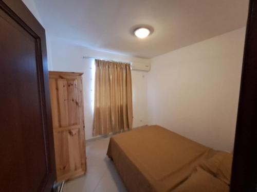 a small bedroom with a bed and a window at Soleil Vacances Loisirs in Flic-en-Flac