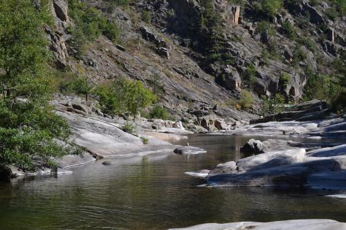 a river with rocks in the middle of a mountain at Chez Lucette in Barjac