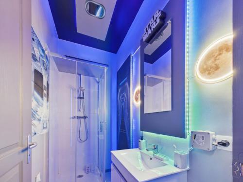 a bathroom with a blue ceiling with a sink and a shower at Star Wars - Faucon Millenium in Troyes