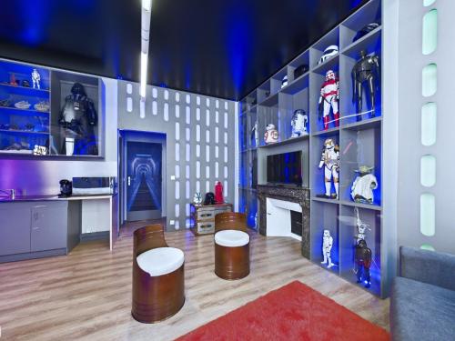 une pièce avec deux tabourets et des étagères avec des jouets dans l'établissement Star Wars - Faucon Millenium, à Troyes