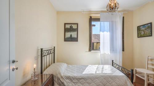 a bedroom with a bed and a window and a chandelier at VILLA CAPPELLETTI 16&2, Emma Villas in Cesi