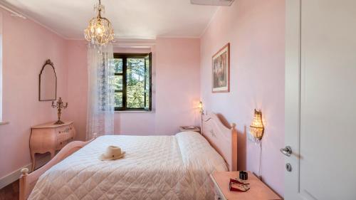 a bedroom with a white bed and a chandelier at VILLA CAPPELLETTI 16&2, Emma Villas in Cesi