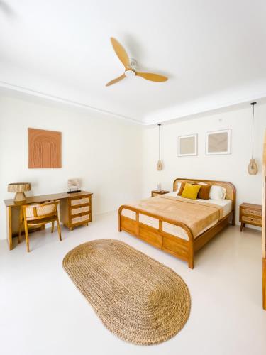 a bedroom with a bed and a ceiling fan at Casa Del La Luna by Nginapsini in Cilama