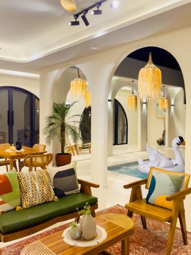a living room with a green couch and a table at Casa Del La Luna by Nginapsini in Cilama