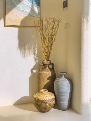 three vases sitting on a shelf in a room at Casa Del La Luna by Nginapsini in Cilama