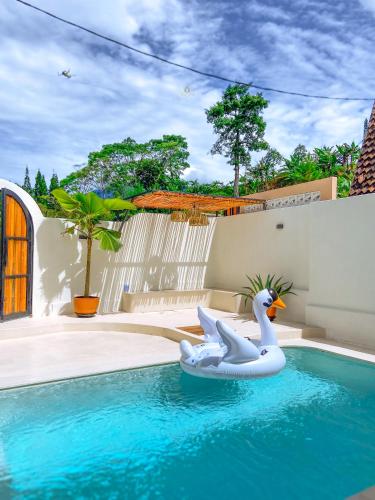 a white swan float in a swimming pool at Casa Del La Luna by Nginapsini in Cilama