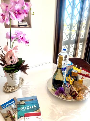 a table with a plate of food and a bottle of wine at Casa Malupo in Casalabate
