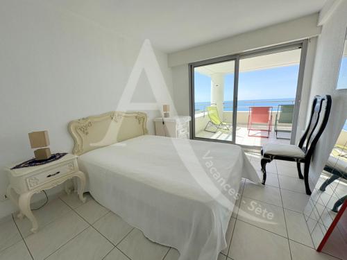 une chambre avec un lit et un balcon avec l'océan dans l'établissement Sur les hauteurs, T4 avec clim, wifi, parking et piescine, à Sète