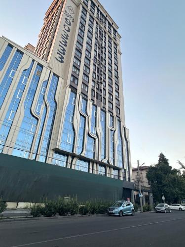 a car parked in front of a large building at Grace apt in Bay Tash Tower in Bishkek