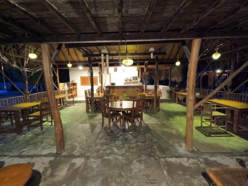 a dining room with wooden tables and chairs at Maryan Moyo Bungalows & Resto in Moyo Island
