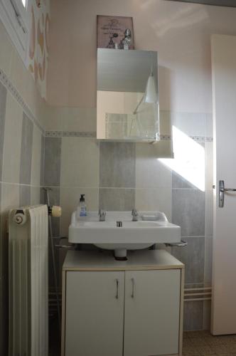 une salle de bain avec un lavabo blanc et un miroir dans l'établissement L'Orée des prés - Gîte de Charme - 3 étoiles, à Ouville-la-Rivière