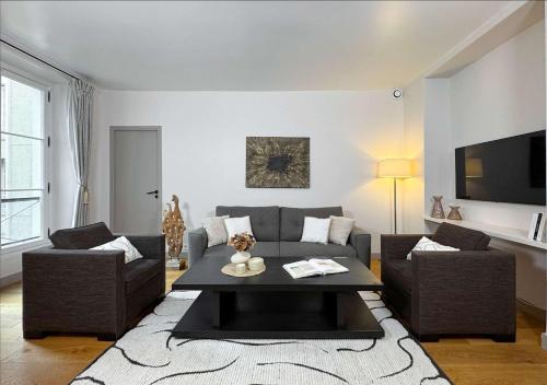 un salon avec un canapé et une table dans l'établissement Luxembourg Garden Family Flat Delight, à Paris