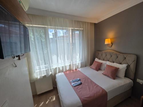 Dormitorio pequeño con cama con almohadas rosas en TAKSİM LİFE HOUSE, en Estambul