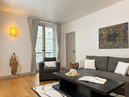 un salon avec un canapé et une table dans l'établissement Luxembourg Garden Family Flat Delight, à Paris