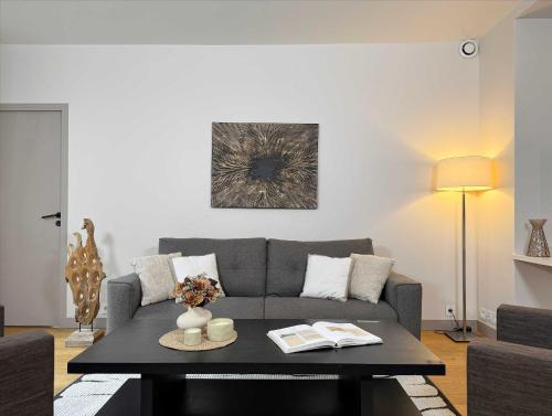 un salon avec un canapé et une table dans l'établissement Luxembourg Garden Family Flat Delight, à Paris