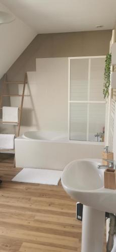 La salle de bains blanche est pourvue d'un lavabo et d'un escalier. dans l'établissement Véro et Domi, à Roézé-sur-Sarthe