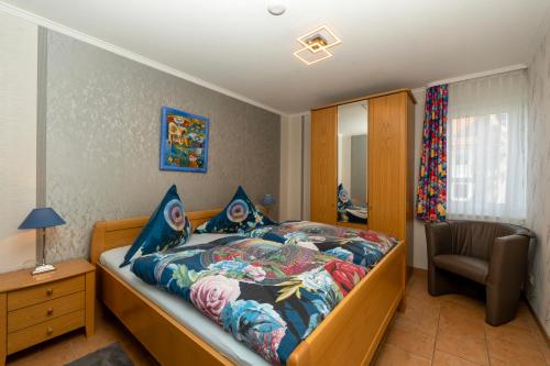 een slaapkamer met een bed en een stoel erin bij Haus Mozart Fewo mit Balkon in Binz