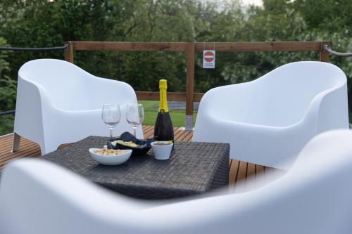 a table with two white chairs and a bottle of wine at Floating Dream in Fiano