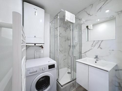 La salle de bains blanche est pourvue d'un lave-linge et d'une douche. dans l'établissement Les Voiles YourHostHelper, à Deauville