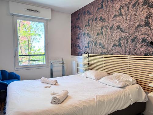 une chambre avec un lit avec deux serviettes dessus dans l'établissement FRUITIERS2 - Bright 3 BR 15' away from the center of Paris, à Saint-Denis