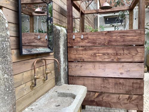 La salle de bains en bois est pourvue d'un lavabo et d'un miroir. dans l'établissement Maison G, à Montréal