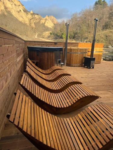 a group of wooden benches sitting on a deck at Villa Melnik SPA Residence with Hot Pool by BookVillaBG in Melnik