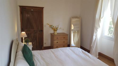une chambre avec un lit, une commode et une fenêtre dans l'établissement Mas de Fantou, à Anglars-Juillac
