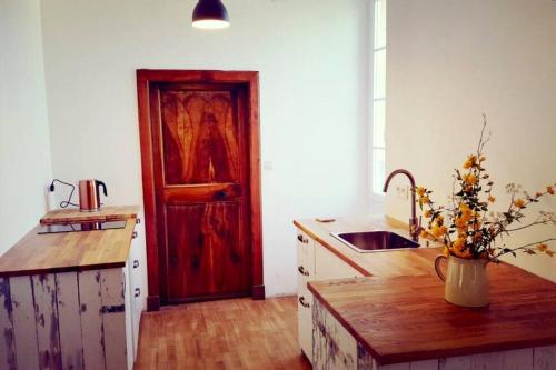 - une cuisine avec un évier et une porte en bois dans l'établissement Mas de Fantou, à Anglars-Juillac