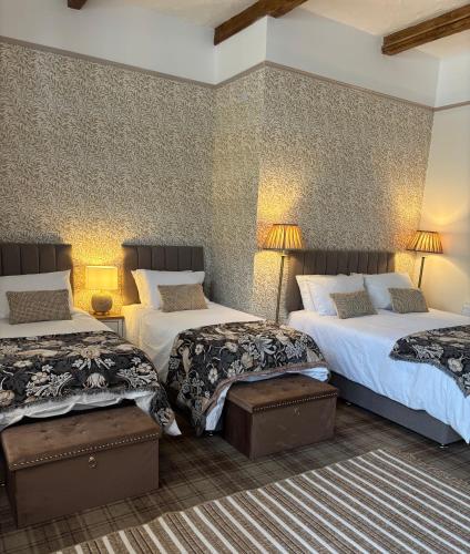 a hotel room with two beds and two lamps at Blenkinsopp Castle Inn in Greenhead
