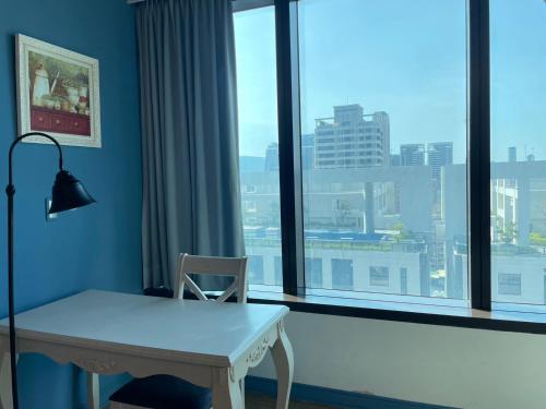 a desk in front of a window with a view at Neo Sky Hotel in Kaohsiung