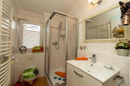 een badkamer met een wastafel en een douche bij Haus Mozart Fewo mit Balkon in Binz