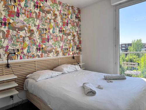 une chambre avec un lit avec une grande fenêtre dans l'établissement FELLINI 3BR with safe parking, à Saint-Denis