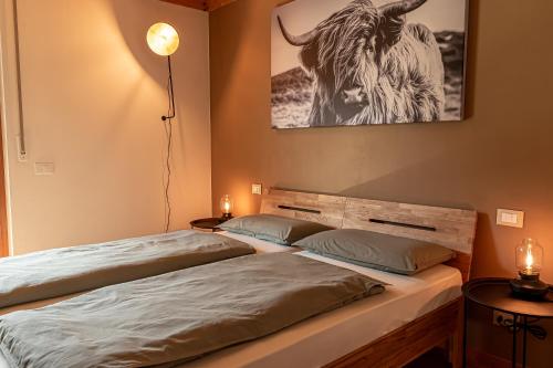 two beds in a room with a picture of a bull at Venosta Valley - At the foot of the Stelvio Pass in Prato allo Stelvio